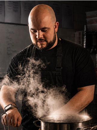 Portrait of a chef in whites and a tall toque